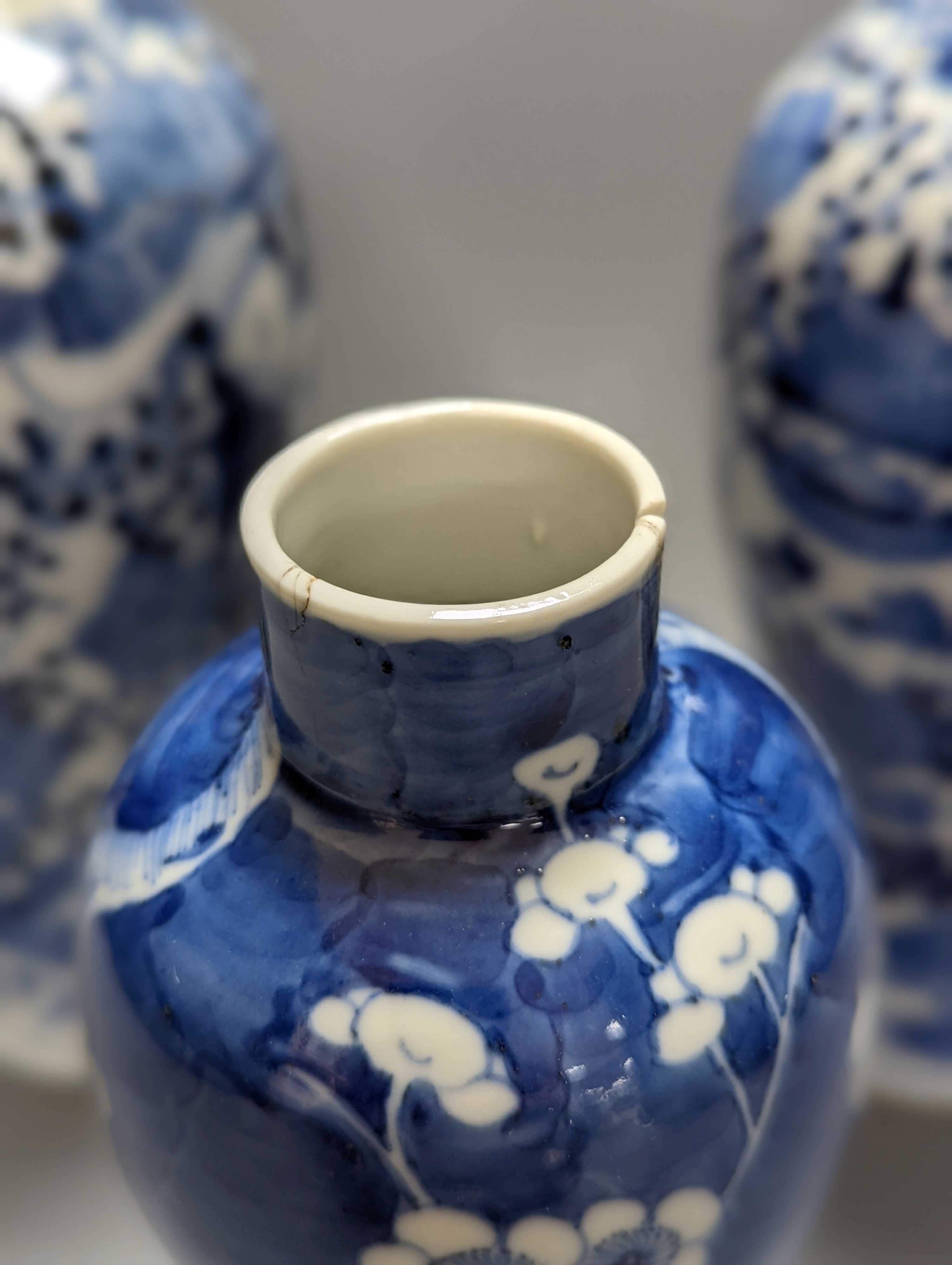 A pair of 19th century Chinese blue and white vases, a prunus vase and cover and a similar jar (4), pair of vases 24 cms high.